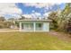 Back exterior view of teal house, showing a covered patio at 1210 Washington St, New Smyrna Beach, FL 32168