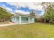 Side view of teal house with covered patio and grassy yard at 1210 Washington St, New Smyrna Beach, FL 32168