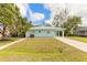 Light teal single-story house with a landscaped yard at 1210 Washington St, New Smyrna Beach, FL 32168