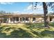 View of home's back, showing a large grassy yard and screened enclosure at 122 Turnbull Villas Cir, New Smyrna Beach, FL 32168