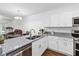 Modern kitchen with granite countertops, stainless steel appliances, and white cabinetry at 122 Turnbull Villas Cir, New Smyrna Beach, FL 32168