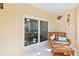 Patio with wicker chair and ottoman, sliding door leading to sunroom at 122 Turnbull Villas Cir, New Smyrna Beach, FL 32168