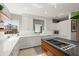 Modern kitchen with white cabinets, stainless steel appliances, and geometric wallpaper at 1309 Hill St, New Smyrna Beach, FL 32169