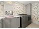 Modern laundry room with gray cabinets and washer/dryer at 1309 Hill St, New Smyrna Beach, FL 32169