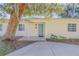 Front entrance of a light yellow house with a teal door and landscaping at 142 Jean Francis Ln, Port Orange, FL 32127