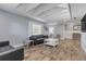 Living room with gray sofas, wood-look floors, vaulted ceilings, and kitchen view at 142 Jean Francis Ln, Port Orange, FL 32127