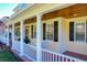 White porch swing on a wraparound porch with yellow siding at 182 Kentucky Blue Cir, Apopka, FL 32712