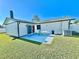 Well-maintained backyard featuring a blue patio, green grass, and a white fence, creating a private outdoor space at 2101 Oriole Ln, South Daytona, FL 32119