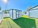 Backyard shed with green grass and white fence, adding storage and charm to the outdoor space at 2101 Oriole Ln, South Daytona, FL 32119