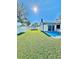 Beautiful backyard featuring a storage shed, blue patio, green grass, and a white fence, perfect for outdoor activities at 2101 Oriole Ln, South Daytona, FL 32119