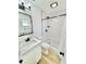 Bright bathroom featuring a modern vanity with marble countertop, black fixtures, and a subway-tiled shower at 2101 Oriole Ln, South Daytona, FL 32119