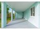 Covered patio with light teal colored walls and cement flooring at 211 Maurice Ave, New Smyrna Beach, FL 32168