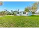 Light teal single story house with a paved driveway and landscaping at 211 Maurice Ave, New Smyrna Beach, FL 32168