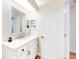 Bathroom with white vanity, a large mirror, and built-in shelving at 216 Fairgreen Ave, New Smyrna Beach, FL 32168