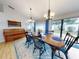 Bright dining area with wooden table and blue chairs, view to backyard at 216 Fairgreen Ave, New Smyrna Beach, FL 32168