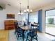 Bright dining room with wooden table and blue chairs, view of backyard at 216 Fairgreen Ave, New Smyrna Beach, FL 32168