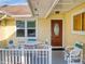 Front porch with seating area and entry door at 216 Fairgreen Ave, New Smyrna Beach, FL 32168