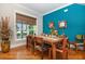 Dining area with rustic wooden table and chairs, and a teal accent wall at 221 Columbus Ave, New Smyrna Beach, FL 32169