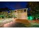 Night view of charming two-story home with lighted fence at 221 Columbus Ave, New Smyrna Beach, FL 32169