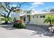 Two-story yellow house with white trim, balcony, and paver driveway at 221 Columbus Ave, New Smyrna Beach, FL 32169