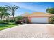 Single story home with a paved driveway and lush landscaping at 236 Quay Assisi, New Smyrna Beach, FL 32169