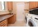 Laundry room with built-in cabinetry, washer, dryer, and exterior access at 236 Quay Assisi, New Smyrna Beach, FL 32169