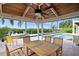 Covered patio overlooking the pool and waterway with wooden table and chairs at 236 Quay Assisi, New Smyrna Beach, FL 32169