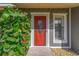 Red front door with glass panels and sidelight at 2507 Milton Ave, New Smyrna Beach, FL 32168