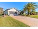 Single-story home with paver driveway, screened garage, and lush landscaping at 258 Navajo Dr, Oak Hill, FL 32759