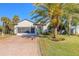 Charming house featuring a paver driveway and mature palm trees at 258 Navajo Dr, Oak Hill, FL 32759