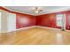 Bright bedroom with red walls and hardwood floors at 2707 Atlantis Dr, New Smyrna Beach, FL 32168