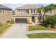 Two-story house with a dark-colored garage door and manicured lawn at 2707 Atlantis Dr, New Smyrna Beach, FL 32168