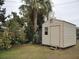 Beige storage shed with a single window and a small set of steps at 2715 Banyan Dr, Edgewater, FL 32141