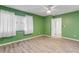 Bedroom with green walls, ceiling fan, and white curtains at 28 Lake Fairgreen Cir, New Smyrna Beach, FL 32168