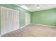 Green-walled bedroom with ceiling fan and light wood flooring at 28 Lake Fairgreen Cir, New Smyrna Beach, FL 32168