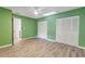 Green bedroom with wood-look floors, double closets and a ceiling fan at 28 Lake Fairgreen Cir, New Smyrna Beach, FL 32168