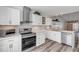 Modern kitchen with white cabinets, stainless steel appliances, and wood-look floors at 28 Lake Fairgreen Cir, New Smyrna Beach, FL 32168