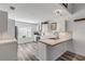 Bright white kitchen features stainless steel appliances and wood-look vinyl flooring at 28 Lake Fairgreen Cir, New Smyrna Beach, FL 32168