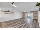 Spacious living room with gray vinyl flooring, sliding doors, and ceiling fan at 28 Lake Fairgreen Cir, New Smyrna Beach, FL 32168