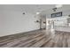 Open living room with high ceiling and wood-look vinyl flooring. Kitchen is visible at 28 Lake Fairgreen Cir, New Smyrna Beach, FL 32168