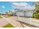 A teal house with white trim and a metal roof, featuring a double garage and a picket fence at 2817 Bay Side Dr, New Smyrna Beach, FL 32168