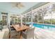 Covered patio with wooden dining table, overlooking the pool at 2817 Bay Side Dr, New Smyrna Beach, FL 32168