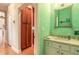 Charming powder room with mint green wallpaper and a white vanity at 2817 Bay Side Dr, New Smyrna Beach, FL 32168