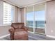 Relaxing ocean view from living room, featuring comfy seating and sliding glass doors at 2947 S Atlantic Ave # 1105, Daytona Beach Shores, FL 32118