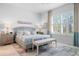 Bright bedroom featuring a king-size bed and large window with plantation shutters at 3037 Borassus Dr, New Smyrna Beach, FL 32168