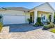 Two-car garage with a paved driveway and landscaping at 3037 Borassus Dr, New Smyrna Beach, FL 32168