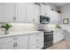 Kitchen with white cabinets and a black stove and microwave at 3037 Borassus Dr, New Smyrna Beach, FL 32168