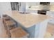 Kitchen island with light colored countertop and four woven stools at 3037 Borassus Dr, New Smyrna Beach, FL 32168