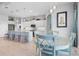 Modern kitchen with white cabinets, a light blue island, and a dining area at 3037 Borassus Dr, New Smyrna Beach, FL 32168