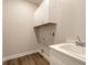 Well-appointed laundry room with white cabinets and a utility sink at 3069 Isles Way, New Smyrna Beach, FL 32168